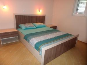 a bedroom with a bed with blue pillows on it at Apartments Marina in Kotor