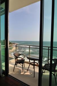 balcone con tavolo, sedie e vista sull'oceano di Apartment L4-5, Oceanfront Condos, Galle, Sri Lanka a Galle