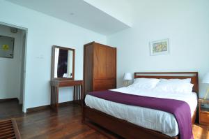 una camera con un grande letto e uno specchio di Apartment L4-5, Oceanfront Condos, Galle, Sri Lanka a Galle