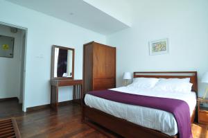 a bedroom with a large bed and a mirror at Apartment L4-5, Oceanfront Condos, Galle, Sri Lanka in Galle +10 photos