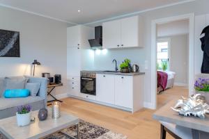 uma cozinha e sala de estar com um sofá e uma mesa em Stadtperle Silver em Westerland