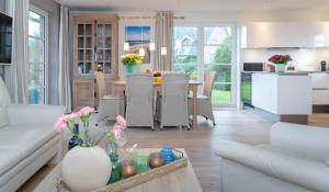 a kitchen and living room with a table and chairs at Traumhaus in Westerland