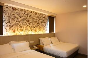 una camera d'albergo con due letti e una finestra di THE CROWN HOTEL @ KLIA a Sepang