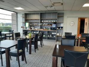 a dining room with tables and chairs and a counter at Cit'Hotel Talencia in Thouars