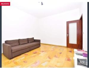 un soggiorno con divano e pavimento in legno di Appartamento al Centro di Valenza a Valenza