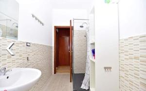 baño con lavabo, espejo y puerta en Appartamento al Centro di Valenza en Valenza
