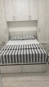 a bed in a room with white cabinets at Apartman Petra in Jagodina