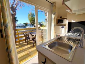 a kitchen with a sink and a view of a balcony at Camping Valencia el Saler in El Saler