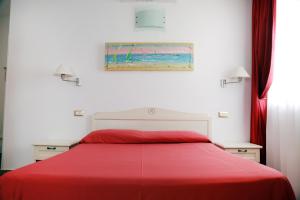 a bedroom with a bed with a red blanket at Hotel Marechiaro - Direttamente sul mare in Vico del Gargano