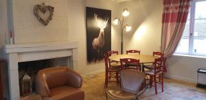 ein Esszimmer mit Tisch und Stühlen und einem Kamin in der Unterkunft Le Clos de La Rousseliere in Francueil