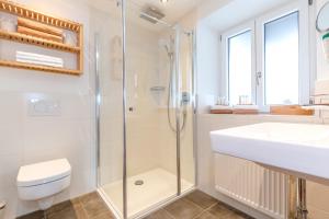 a bathroom with a shower and a sink and a toilet at Gästehaus Menkenbauer in Ruhpolding