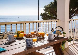 a table with food and orange juice on the beach at Terrazza Lungomare, e sei in spiaggia... in Cala Gonone