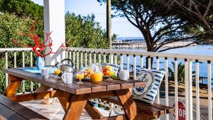 a wooden table with glasses of orange juice on a porch at Terrazza Lungomare, e sei in spiaggia... in Cala Gonone +26 photos