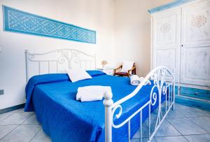 a blue and white bed in a white bedroom at Terrazza Lungomare, e sei in spiaggia... in Cala Gonone