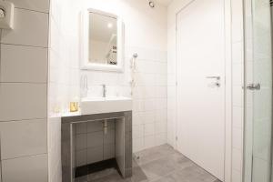 a white bathroom with a sink and a mirror at LE MADAMINE ROOMS in Turin