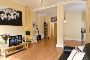 a living room with a couch and a television on a table at Beatles Apartment in Liverpool