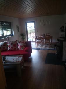 a living room with a red couch and a table at Ferienwohnung im idyllischen Neckartal in Starzach