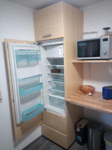 una nevera con la puerta abierta y un microondas en Ferienwohnung im idyllischen Neckartal, en Starzach