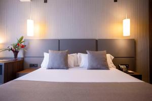 sypialnia z dużym łóżkiem z białymi poduszkami w obiekcie Panafrica Hotel Boutique & Spa w Bacie