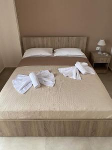 a bed with two towels and two pillows on it at Theo and Irin's Houses in Flogita