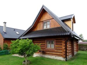 a log cabin with a black roof at Domek Z Bali Góral in Kopalino