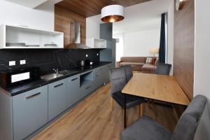 a kitchen with a wooden table and a dining room at APLEND Vila Magnolia - Tatry Card v cene in Tatranská Lomnica