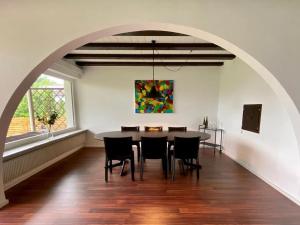 a dining room with a table and chairs and a painting at Bodensee Bungalow in Immenstaad am Bodensee