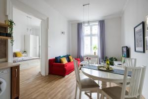 - un salon avec une table et un canapé rouge dans l'établissement Lubicz Apartment next to Main Station Netflix, à Cracovie