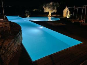 a swimming pool at night with blue lighting at Masseria Trulli&Stelle B&B in Noci
