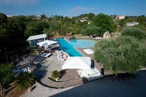 an overhead view of a swimming pool with an umbrella at Masseria Trulli&Stelle B&B in Noci