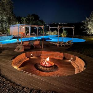 a fire pit in the middle of a patio at night at Masseria Trulli&Stelle B&B in Noci
