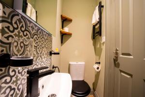 a bathroom with a toilet with a black and white patterned wall at The Crown Hotel in Glastonbury