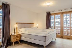 a bedroom with a large white bed and a window at Chalet La Gioventu in Grindelwald