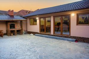 a patio in front of a house with a fireplace at CASA ALESIA SI ERIC in Jiblea Veche