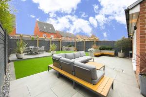 a patio with a couch and a table at Stunning 4 Bed House with Cinema Room & Parking in Manchester