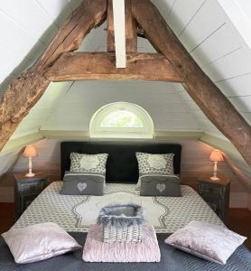 a bedroom with a bed in an attic at LES 2 CHAUMIÈRES Piscine & Spa in Ablon