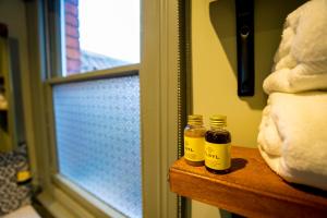 two bottles of honey sitting on a table next to a window at The Crown Hotel in Glastonbury