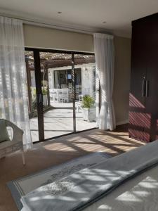 a bedroom with a bed and a sliding glass door at Brighton Bay in St Francis Bay