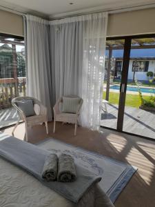 a bedroom with a large bed and a large window at Brighton Bay in St Francis Bay