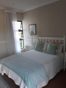 a bedroom with a large white bed with a window at Brighton Bay in St Francis Bay +21 photos