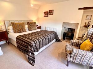 1 dormitorio con cama, chimenea y sofá en Jewel Cottage, en Matlock