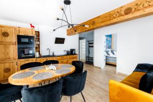 a kitchen and dining room with a table and chairs at Apartament Góral-Ski in Białka Tatrzańska