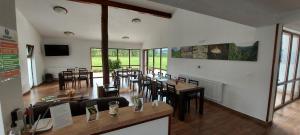 a dining room with tables and chairs and windows at Popasul din Lunca in Pui