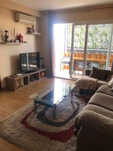 een woonkamer met een bank en een glazen salontafel bij Family-Appartment in Santa Pola