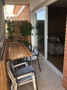 een patio met een houten tafel en stoelen op een balkon bij Family-Appartment in Santa Pola