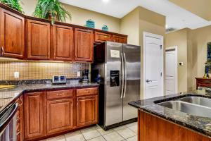 a kitchen with wooden cabinets and a stainless steel refrigerator at Villa Vista in Hollister