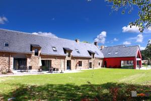 a large brick building with a red barn at Gîte Avalon - Closeries du Golfe in Theix
