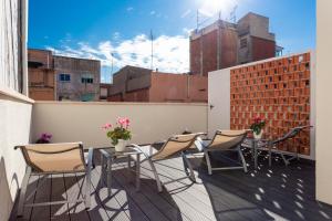 een patio met stoelen en tafels op een balkon bij 8 lacus in Hospitalet de Llobregat
