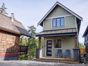 a tiny house with two chairs on the porch at Storm Bay, Family Home with Hot Tub and Inlet View in Ucluelet