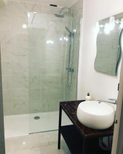 a white bathroom with a sink and a shower at La casa Trivala in Carcassonne